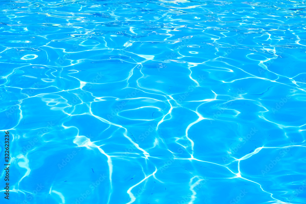Surface of blue swimming pool. Background of water in swimming pool. Shining blue water ripple background. 