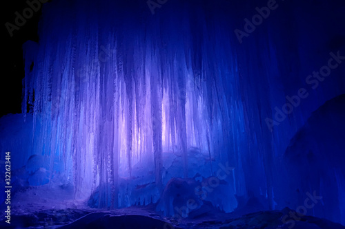 Cuadro en lienzo A massive wall of long ice stalactites are illuminated by a few rays of light