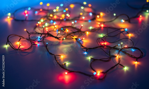 electric wire messy garland on the color surface of table in dark place © Mihail