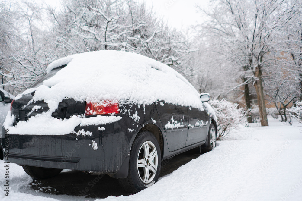 the car covered by snow in the morning on the parking lot during winter season the car covered by snow in the morning on the parking lot during winter season