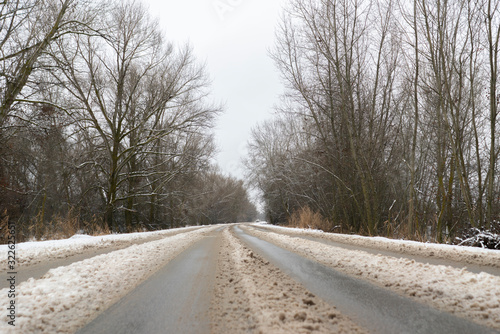 the snowy highway road going through the forest and trees, winter season