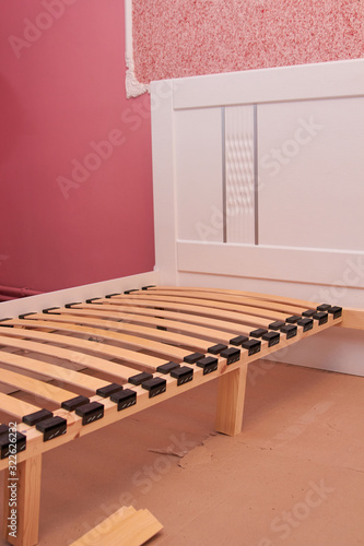 wooden bed frame,part of the bed frame housing when assembled in a room