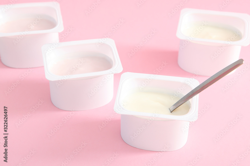 Tasty yogurt in a plastic glass on a colored table. Place to insert text. Useful snack. Tasty yogurt in a plastic glass on a colored table. Place to insert text. Useful snack.