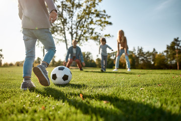 Are You Ready for Some Football. Happy family playing with a ball on meadow