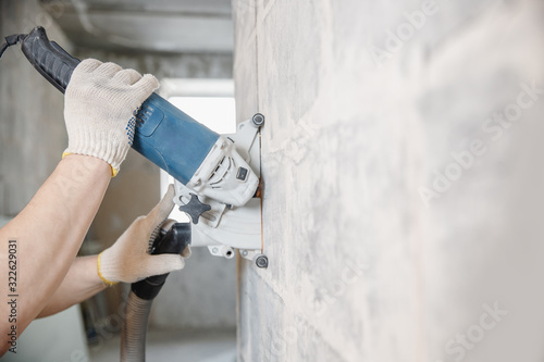 Εκτύπωση καμβά Builder worker cutting electrical chase in concrete wall with circulation saw dr