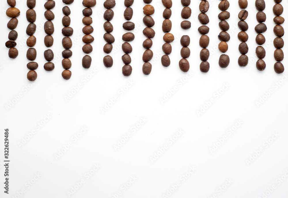 brown coffee beans on white paper background. Coffee beans at the top of the picture brown coffee beans on white paper background. Coffee beans at the top of the picture
