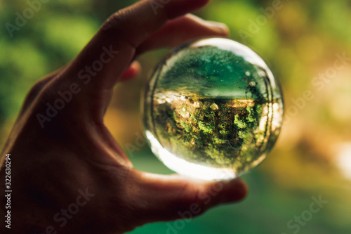 Retrato de paisaje con esfera sostenida con una mano