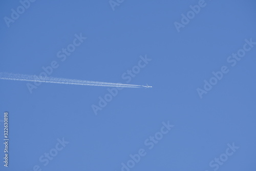 clear blue sky with random traces of burned fuel from the plane on a clear Sunny day.