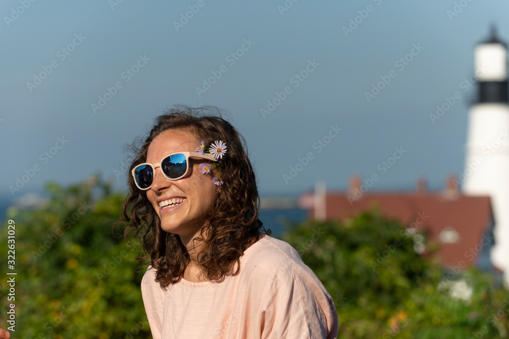 A smiling woman near a lighthouse. A smiling woman near a lighthouse.
