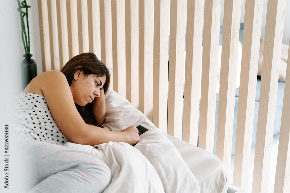 Woman Lying in bed And Resting With Smartphone Woman Lying in bed And Resting With Smartphone