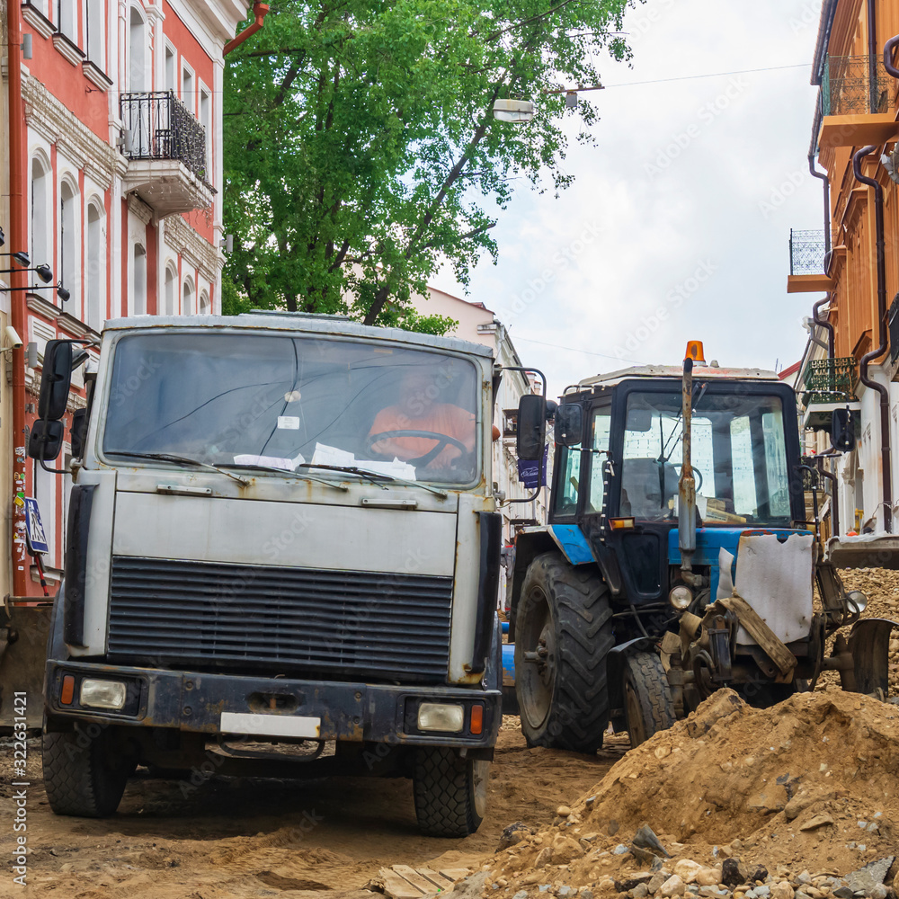 Town centre reconstruction after city water system was rebuilt. Truck and tractor stands in the beautiful historic center of the city on the site of repair work