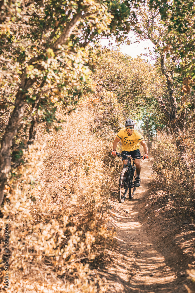Young male rides Mountainbike on dusty single trail Young male rides Mountainbike on dusty single trail