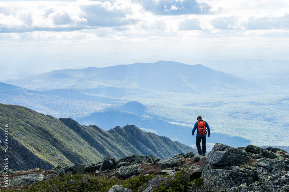 Silhouetted hiker with mountains in the distance Silhouetted hiker with mountains in the distance