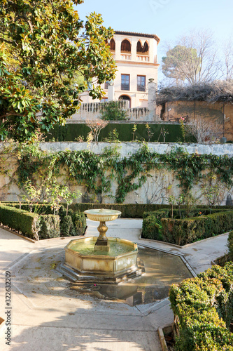 Beautiful fountain under the tree in the cosy garden