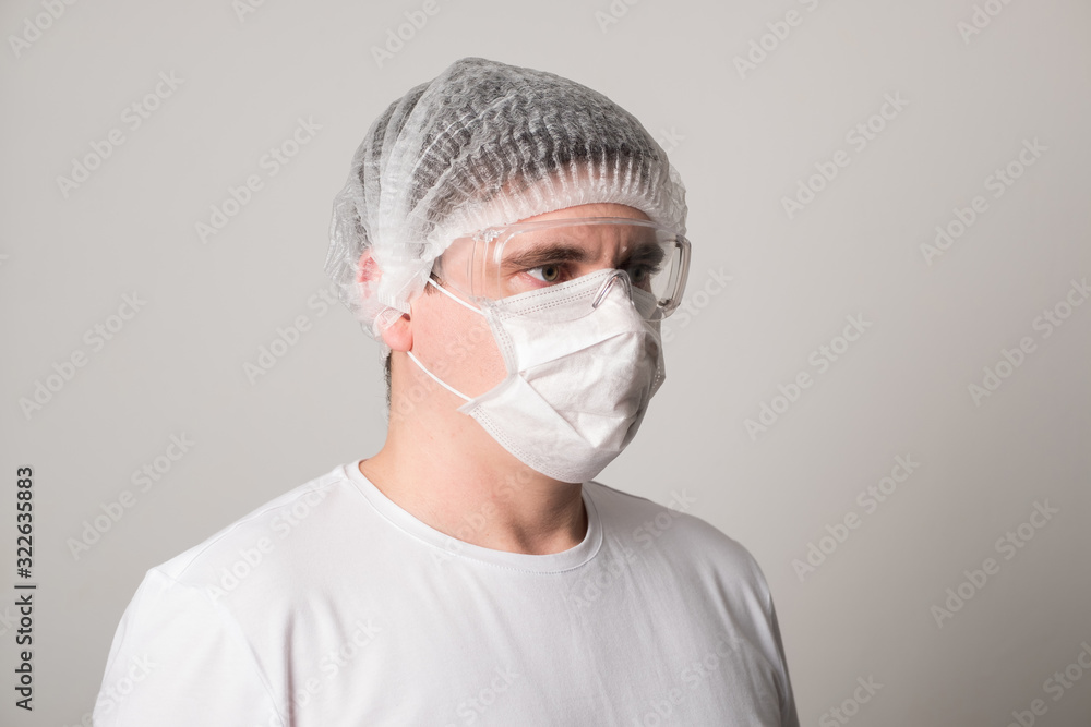 Male doctor in a surgical mask and glasses. Surgeon before the operation. Young man in a medical mask. Male doctor in a surgical mask and glasses. Surgeon before the operation. Young man in a medical mask.