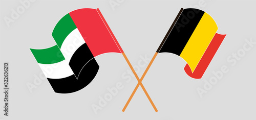 Crossed and waving flags of Belgium and the United Arab Emirates