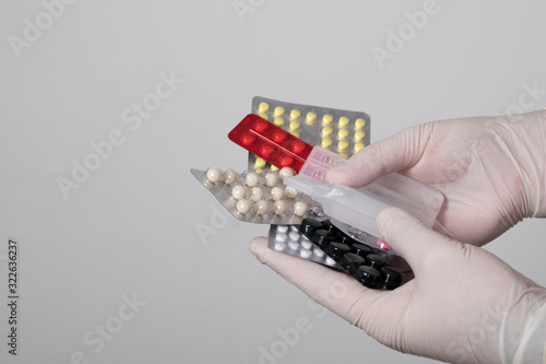 Pills in the hands. Male hands in surgical gloves hold packs of pills.