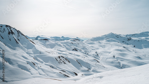 Panoramica de un paisaje montañoso nevado con unas vistas a unas pistas de esquí con telesillas photo