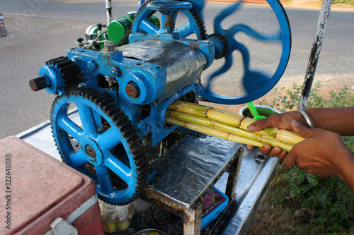 blue bamboo juice machine with green bamboo branches in hand