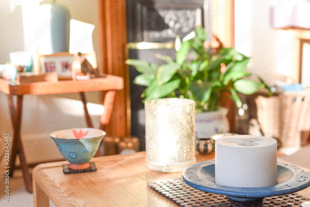 Stylish home interior in natural daylight from window with candle ornament on coffee table Stylish home interior in natural daylight from window with candle ornament on coffee table
