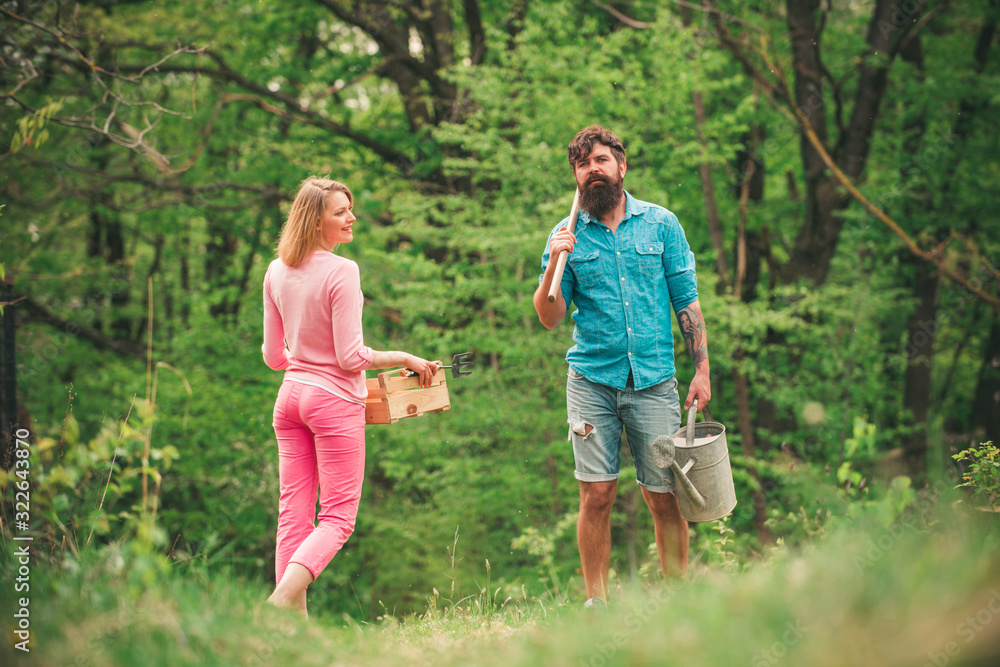 Obraz premium Portrait of a young happy couple in yard during spring season. Farming and agriculture cultivation. Farmers couple working in field.