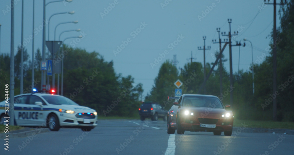 View of self-willed young man driving on modern sports car from the police. Police officer cop chasing a thief driving a patrol car on the highway at daytime. Police in pursuit.