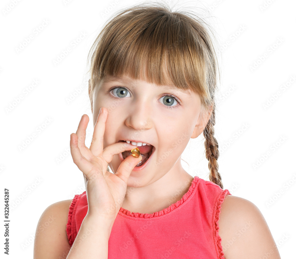 Little girl taking fish oil pill against white background Little girl taking fish oil pill against white background