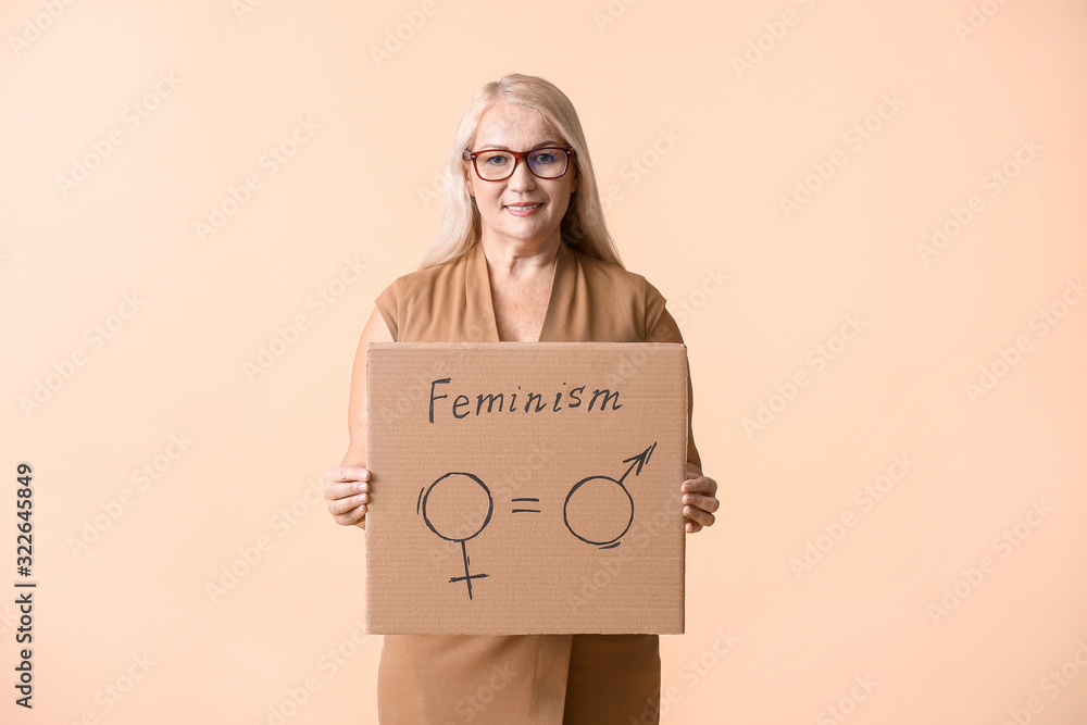 Lady holding cardboard with symbols of man and woman on color background. Concept of feminism Lady holding cardboard with symbols of man and woman on color background. Concept of feminism