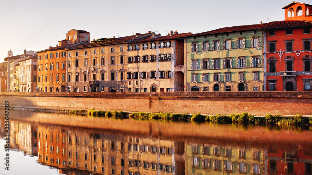 Beautiful architecture in Pisa, Italy. Colorful buildings at the river in morning time.