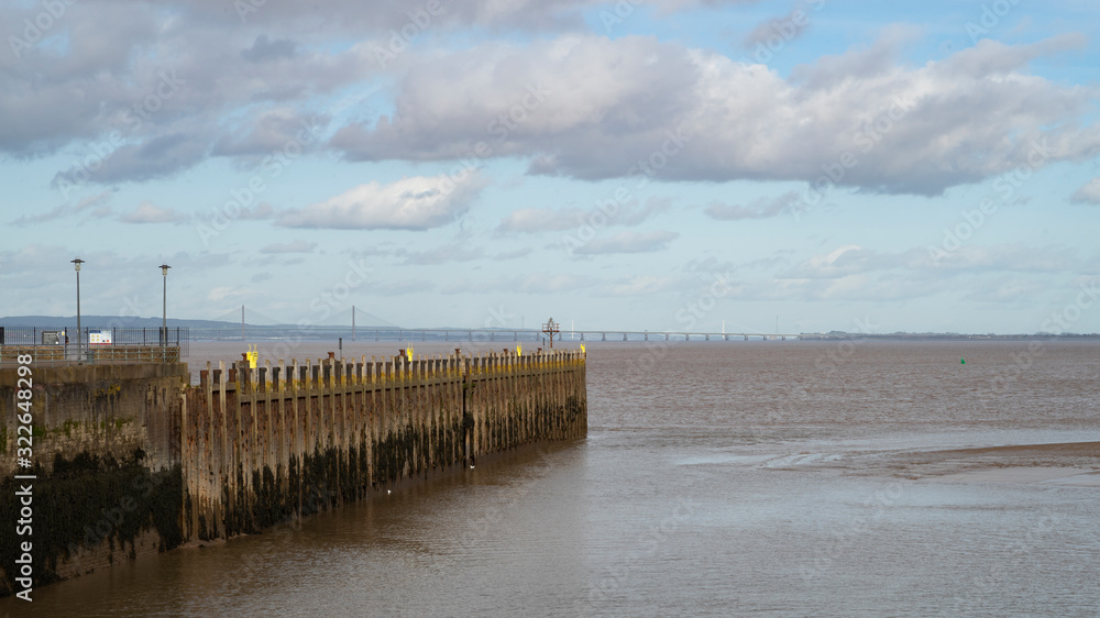 A view of the Severn Estuary near Bristol, England UK with the new road bridge in the distance and Portishead pier in the foreground.