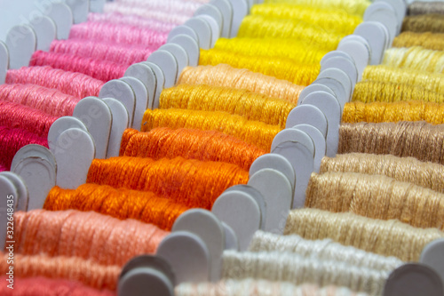 Colorful embroidery floss cross stitch string kit prewound on bobbins for crafts and hobbies. Multicolor thread on cardboard. 