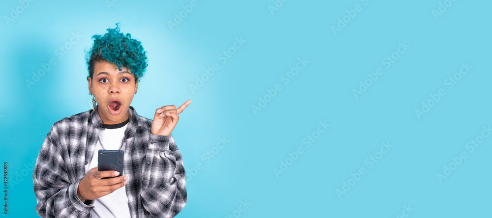 african american girl or woman with mobile phone or smartphone isolated on blue background