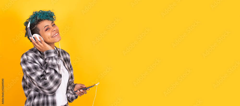 young brunette girl with mobile phone and headphones isolated on background