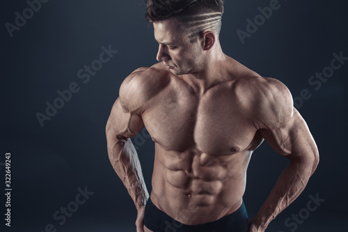 Strong Athletic Sexy Muscular Man on Black Background. © zamuruev