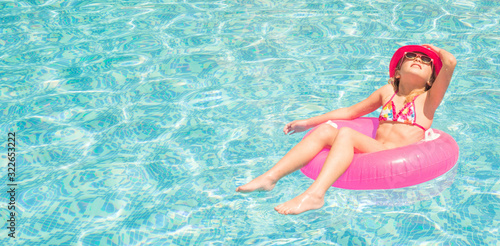 Pretty little girl in swimming pool, summer vacations.