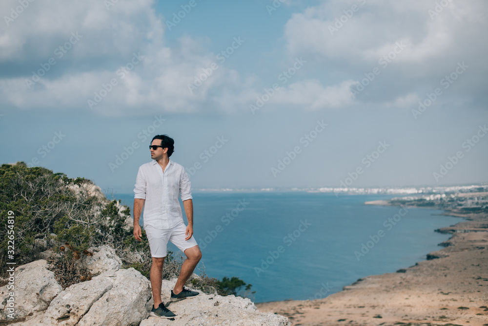 A man on the rocks overlooking the sea