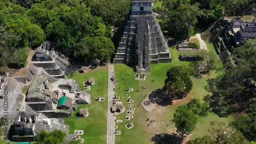 Aerial, tilt up, drone shot away from the Tikal ruins of a ancient city, sunny day, in Flores, Guatemala, Central America
