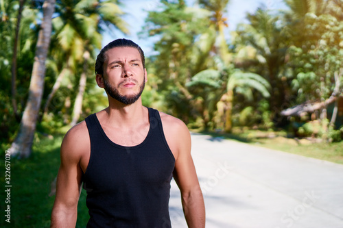 Outdoor portrait of serious young bearded man.