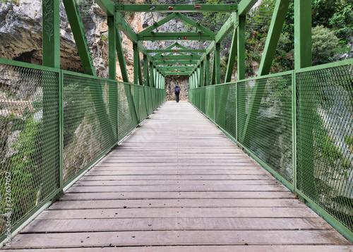 Fényképezés Woman crossing a metallic bridge during a hiking holiday in northern Spain