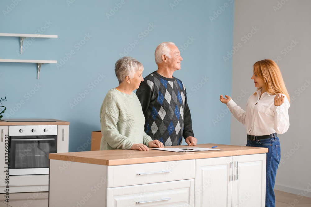 Female real estate agent working with senior couple indoors Female real estate agent working with senior couple indoors