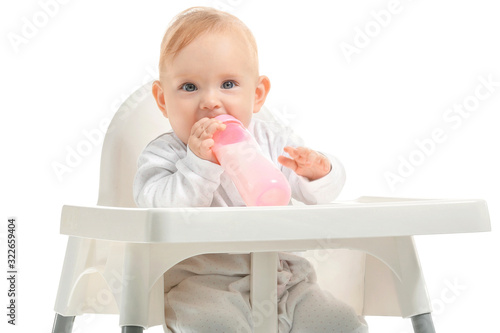 Baby with bottle of milk sitting in high-chair on white background