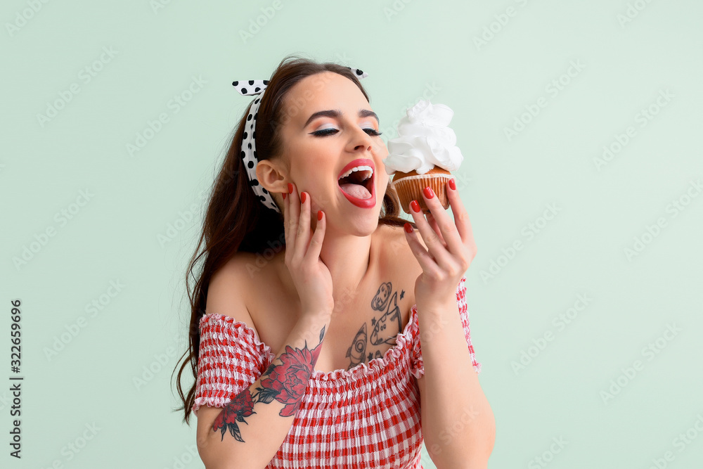 Beautiful housewife with cupcake on color background Beautiful housewife with cupcake on color background
