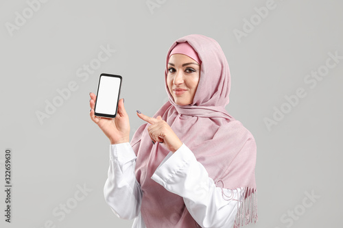 Young Arab woman with mobil...