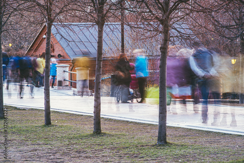 A crowd of blurred people walking in the autumn Park. Blurred image