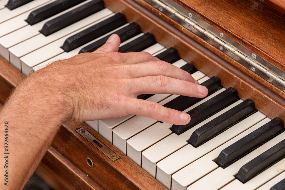 Fototapeta premium Male pianist hand on piano keyboard