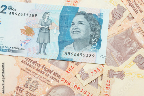 Wallpaper Mural A close up image of a blue two thousand Colombian peso bank note on a background of Indian ten rupee bank notes in macro Torontodigital.ca