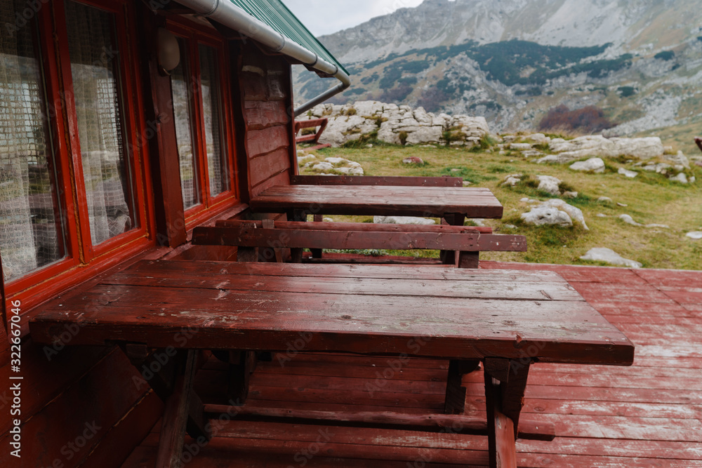 Tables on rustic wooden terace by the house with mountain view Tables on rustic wooden terace by the house with mountain view