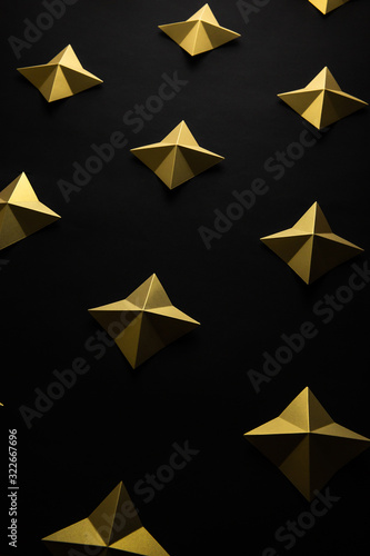 Luxury geometric gold stars on black paper background pattern