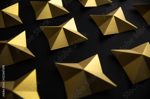 Luxury geometric gold stars on black paper background pattern