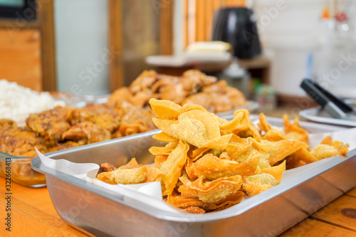 a lot of homemade Thai deep fried wonton in aluminum plate prepare for Asia noodle style.